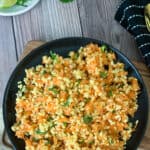 Raw carrot salad recipe served in a black plate.