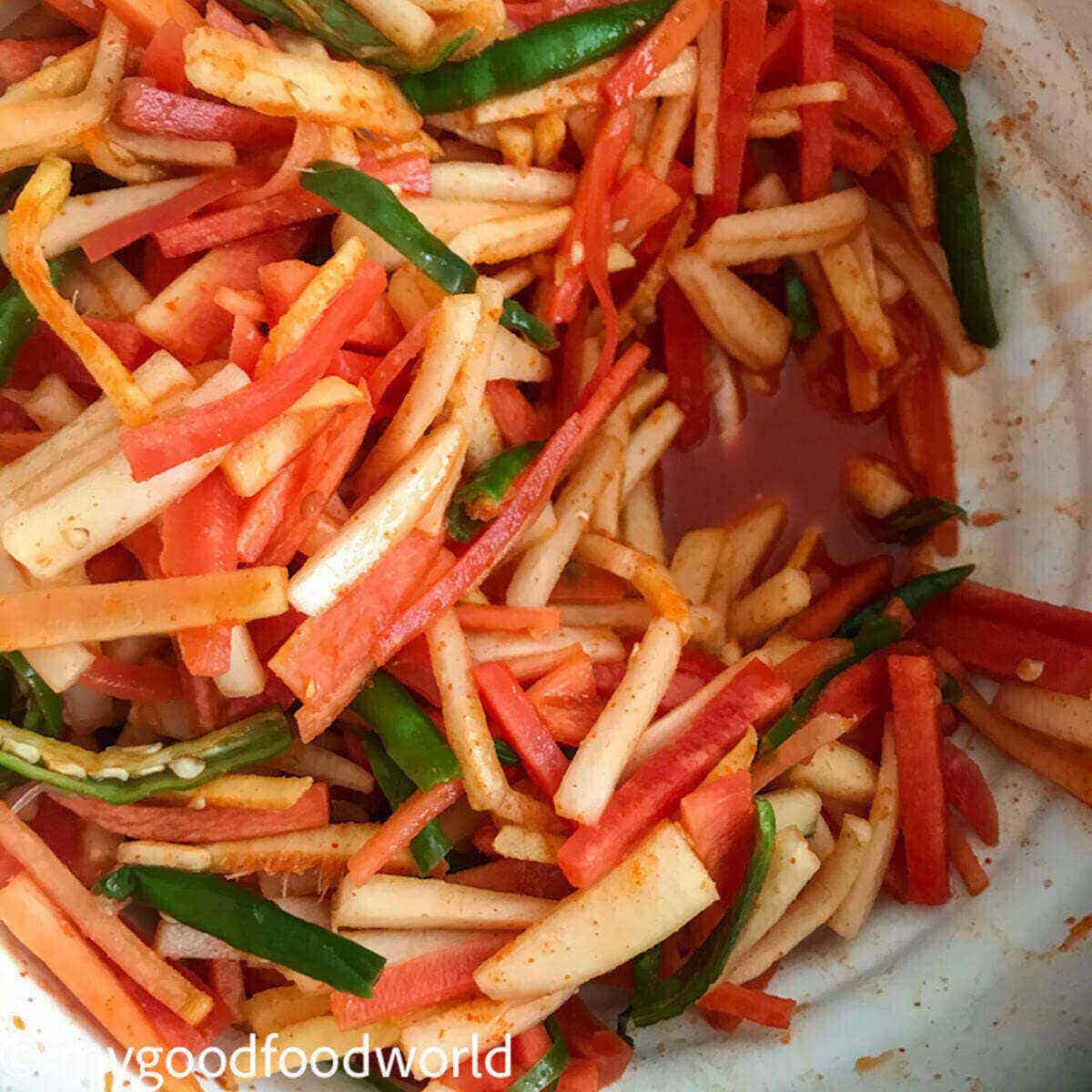 Thinly sliced carrots, mooli, green chillies and ginger in pickling juice.