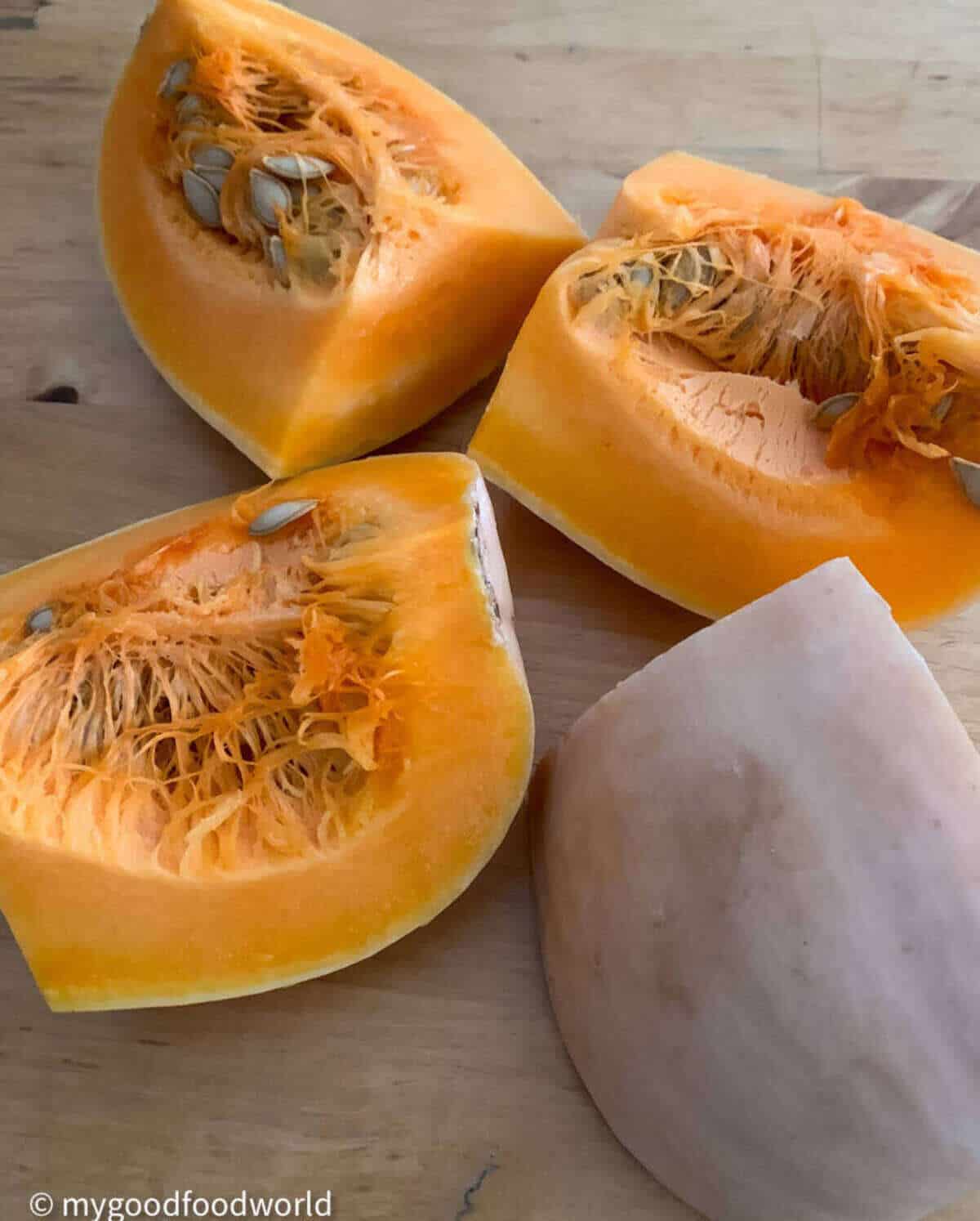 Four chunky pieces of butternut squash placed on a table.
