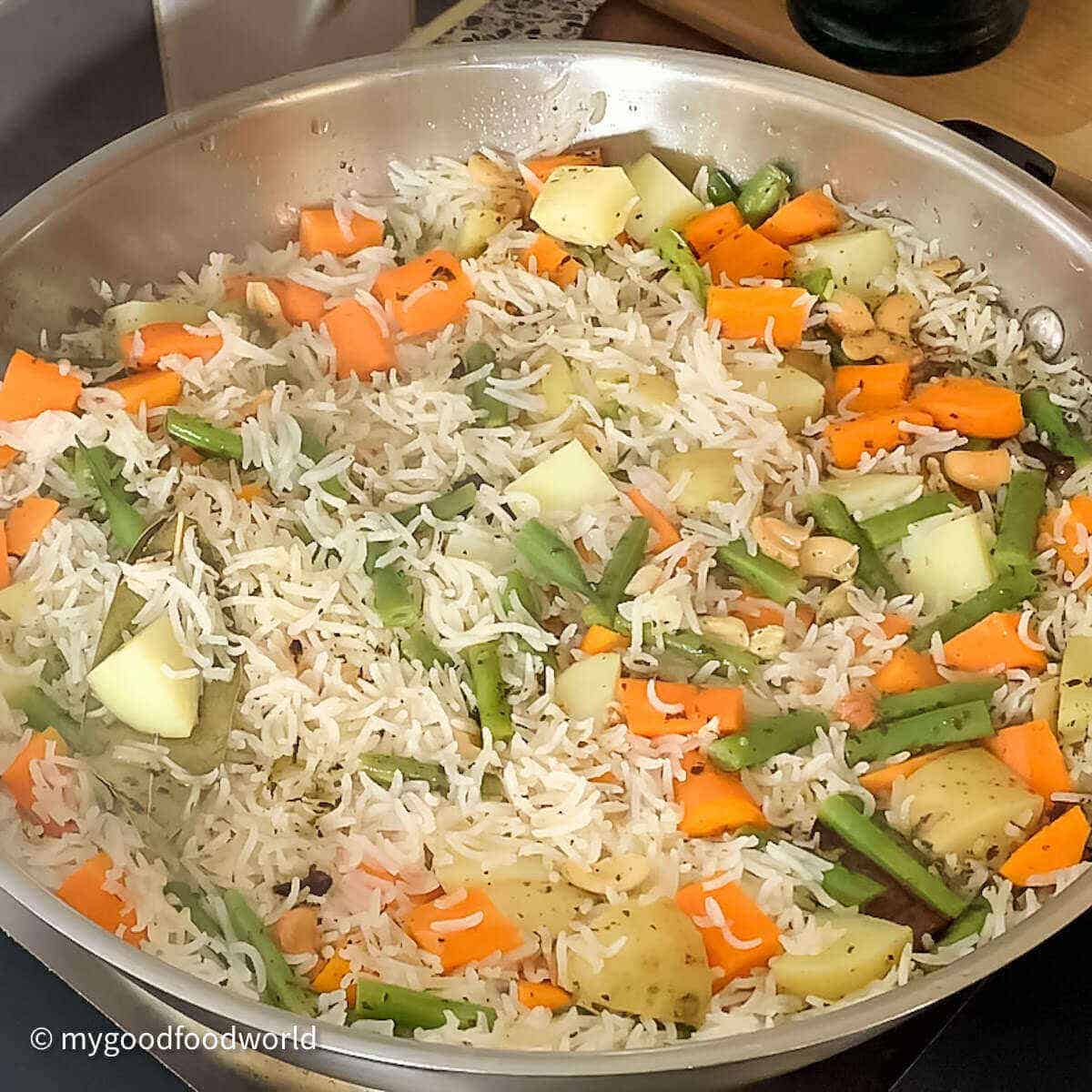 Cooked veg pilav rice in a wide pan.