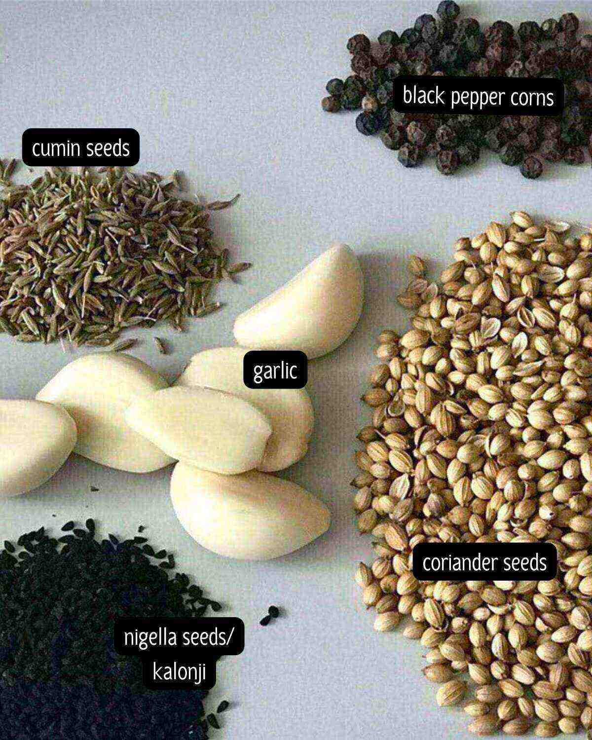 Ingredients for garlic pepper seasoning placed on a light blue background.