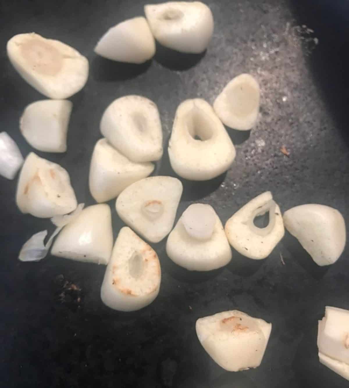Garlic slices roasted in a cast iron pan.