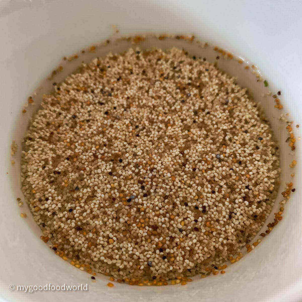 Poppy seeds soaking in warm water and placed in a white bowl.