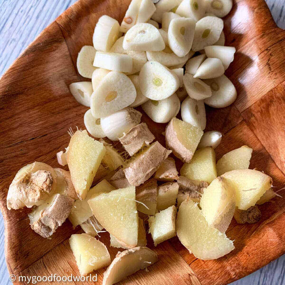 Chopped pieces of ginger and garlic placed in a wooden plate. 