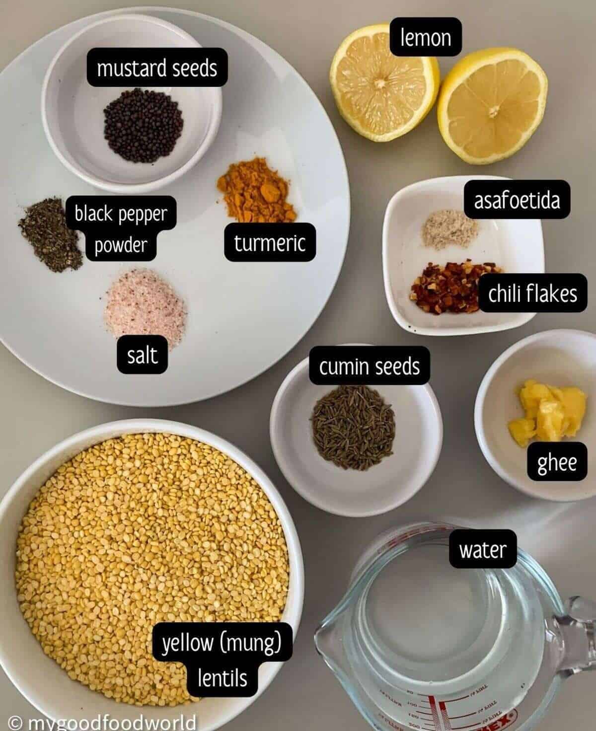 Ingredients for yellow lentil stew placed in bowls and plates on a light grey background.