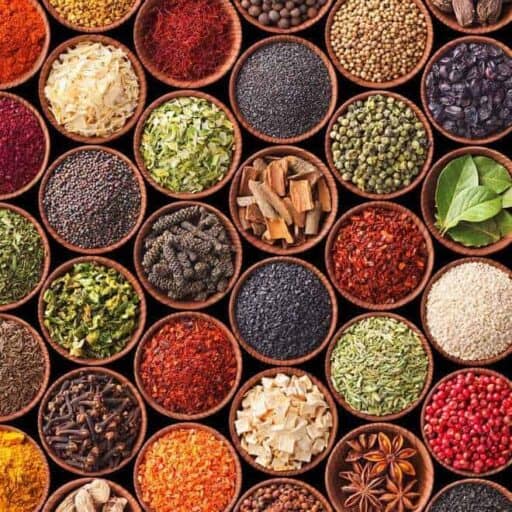 A display of colorful Indian spices placed in round bowl close to each other.