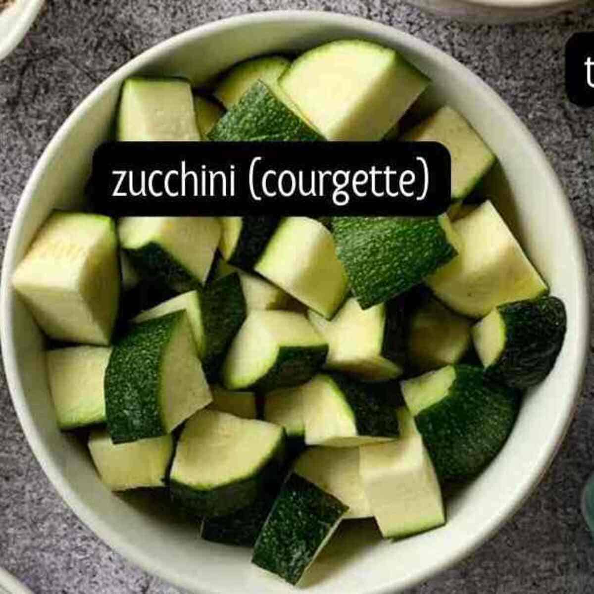 Diced zucchini placed in a white round bowl.