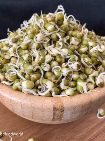 To answer the questions about how to grow thick mung bean sprouts, this is an image of sprouted mung beans placed in a heap in a wooden bowl.