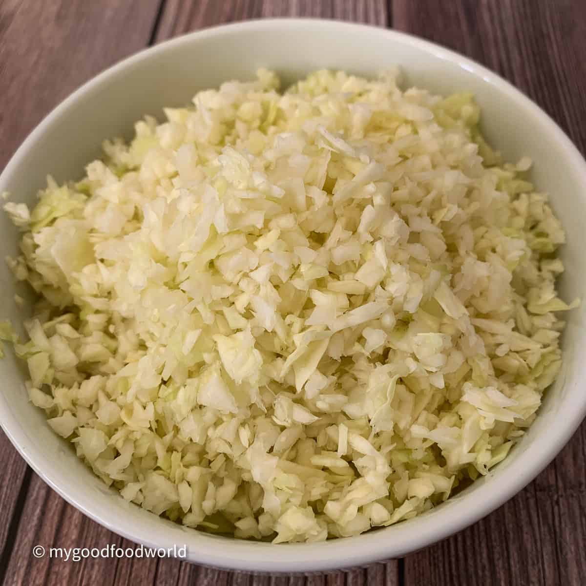 A close-up picture of finely chopped muttaiakose placed on a white round bowl.