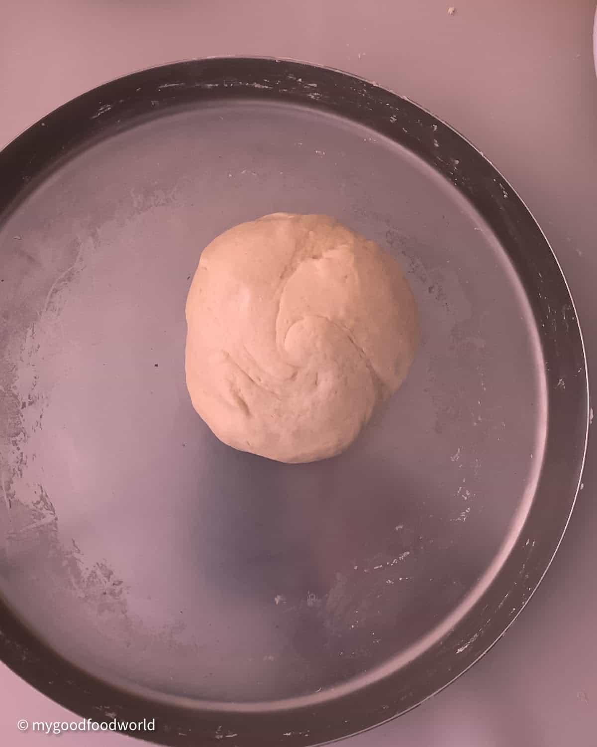 Soft, well kneading and smooth looking ball of dough is placed in the centre of a big steel plate.