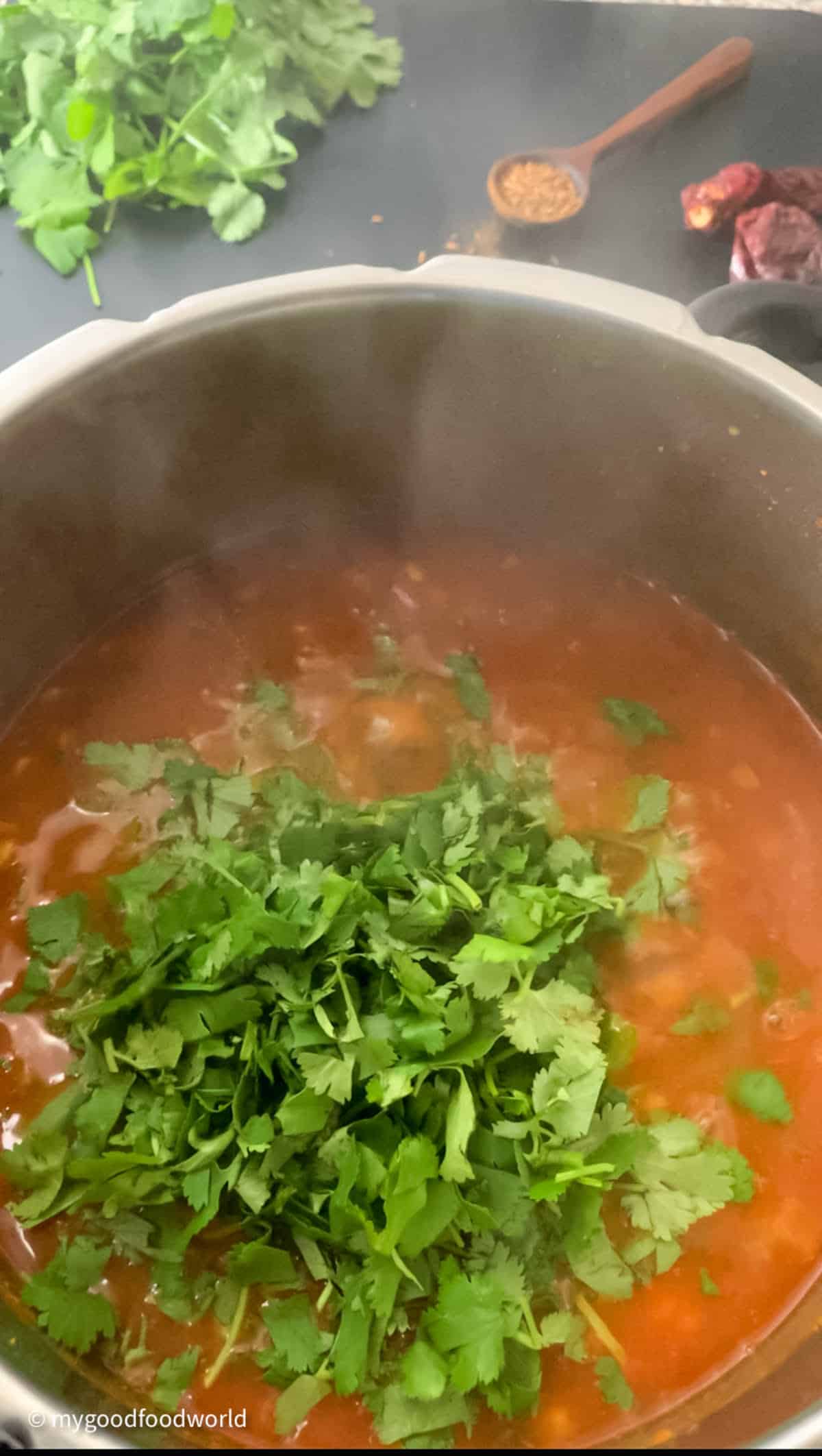 A pot of dal cooking with some chopped fresh cilantro on top.
