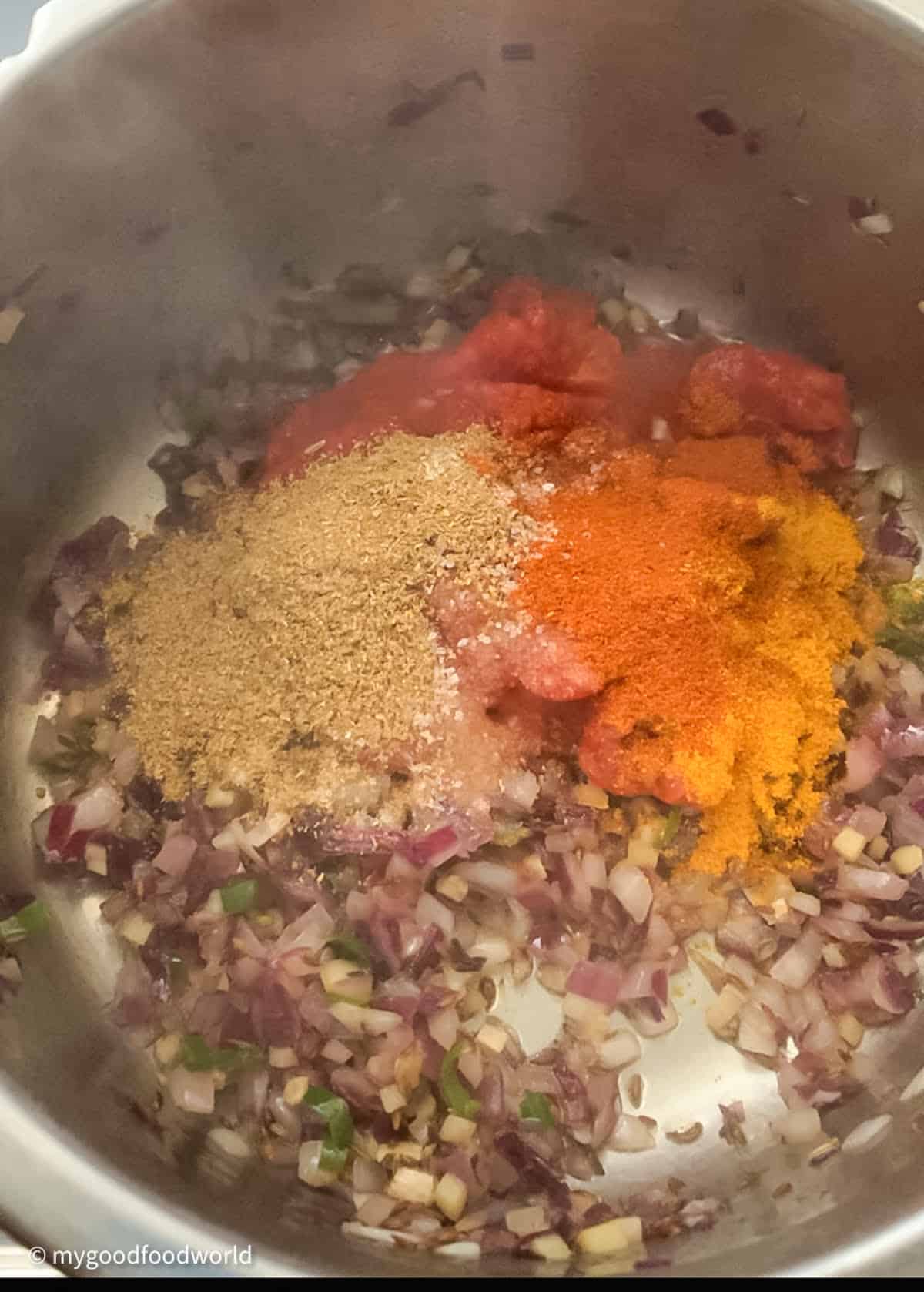 Chana dal fry recipe is being made with some spice powders and aromatics that are frying in a steel pot.