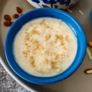 Creamy rice pudding is served in a blue round bowl.