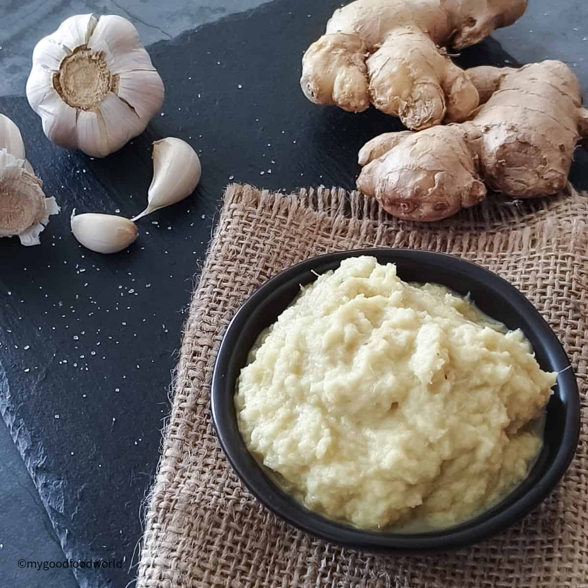 To learn how to make ginger garlic paste at home, some fresh ginger, garlic, and puree are placed on a table.