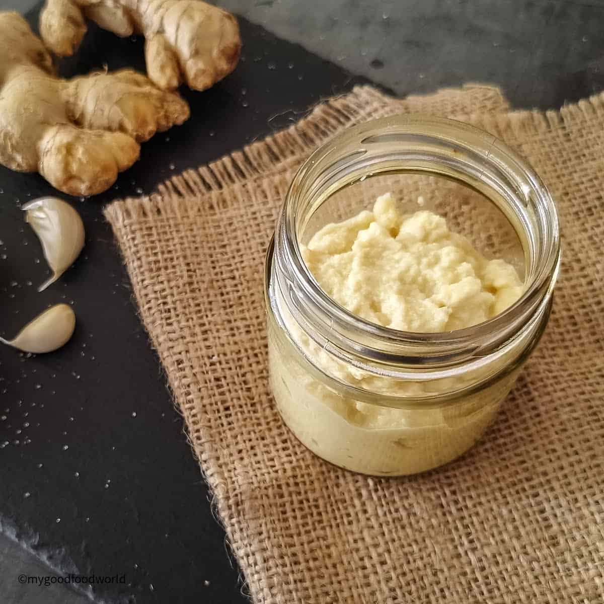 Freshly made homemade adrak lahsun paste is placed in a glass bottle.