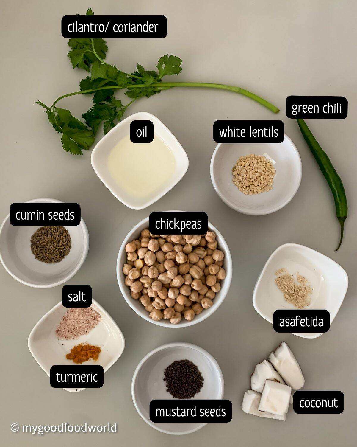 Ingredients for chickpea sundal including dried chickpeas, fresh coconut, curry leaves, green chilli, and whole spices.
