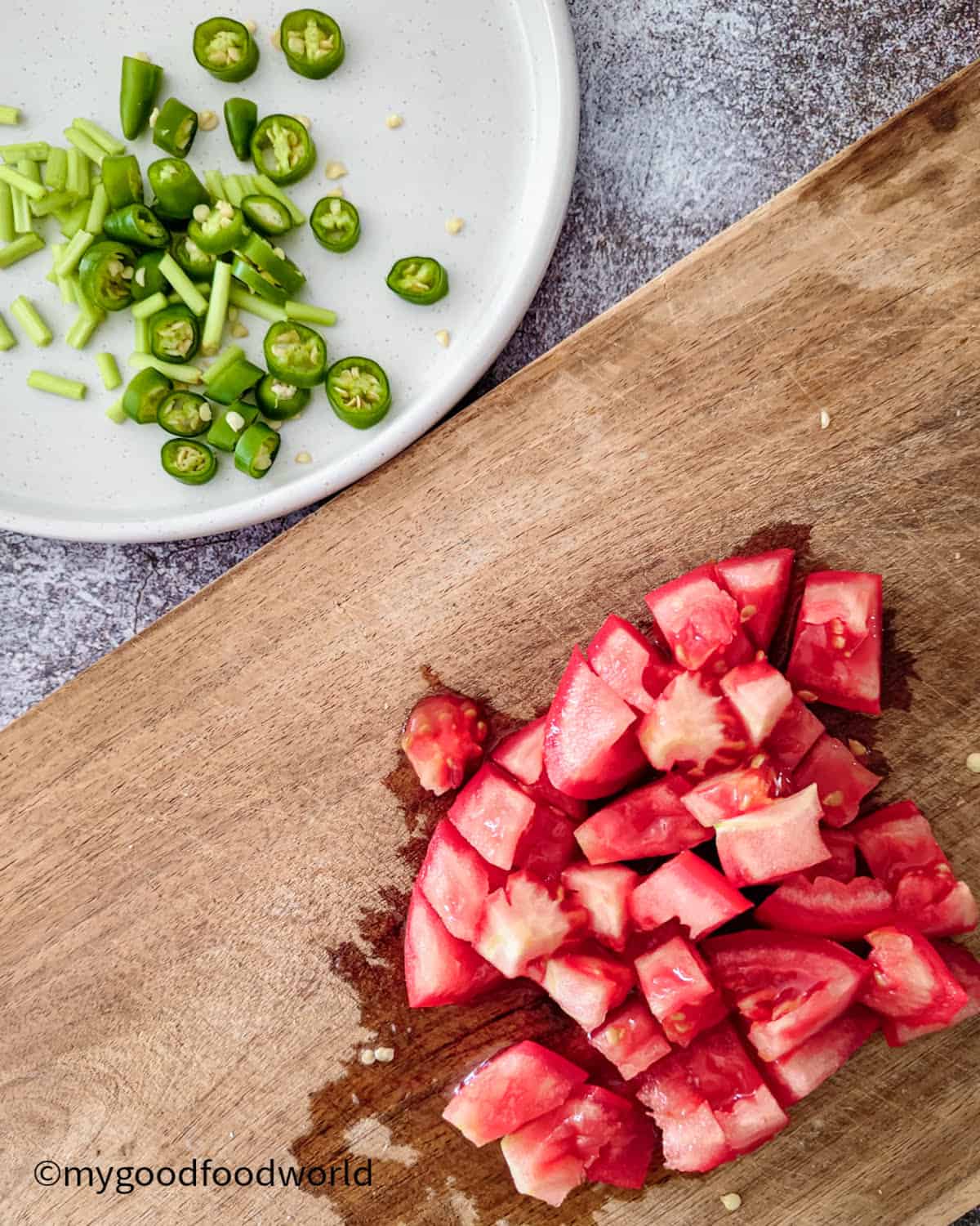 Some chopped tomatoes, green chili peppers, and cilantro stems.