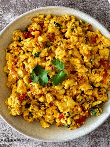 Close-up of paneer bhurji in a bowl, a scrambled and spiced Indian paneer dish garnished with coriander.