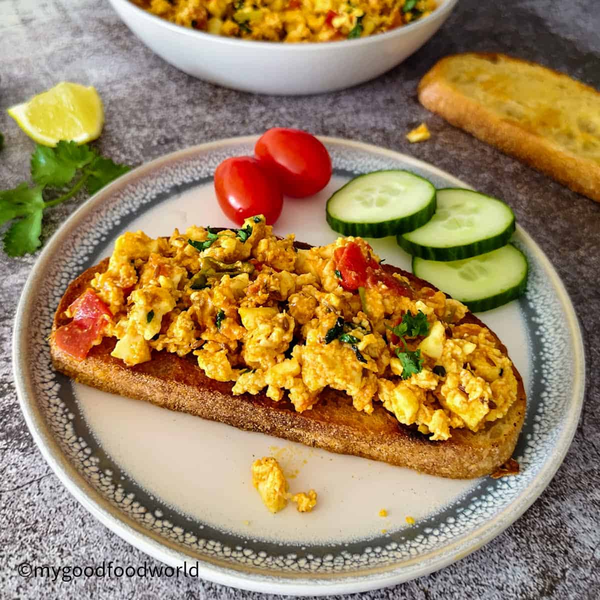 Spiced paneer bhurji piled on toasted sourdough, served with cherry tomatoes and cucumber slices.
