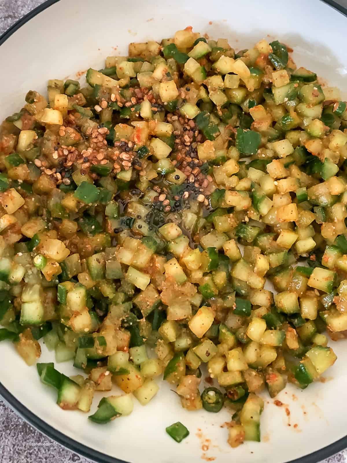 Fried tempering is being added and mixed with mukkala keera dosakaya pachadi.