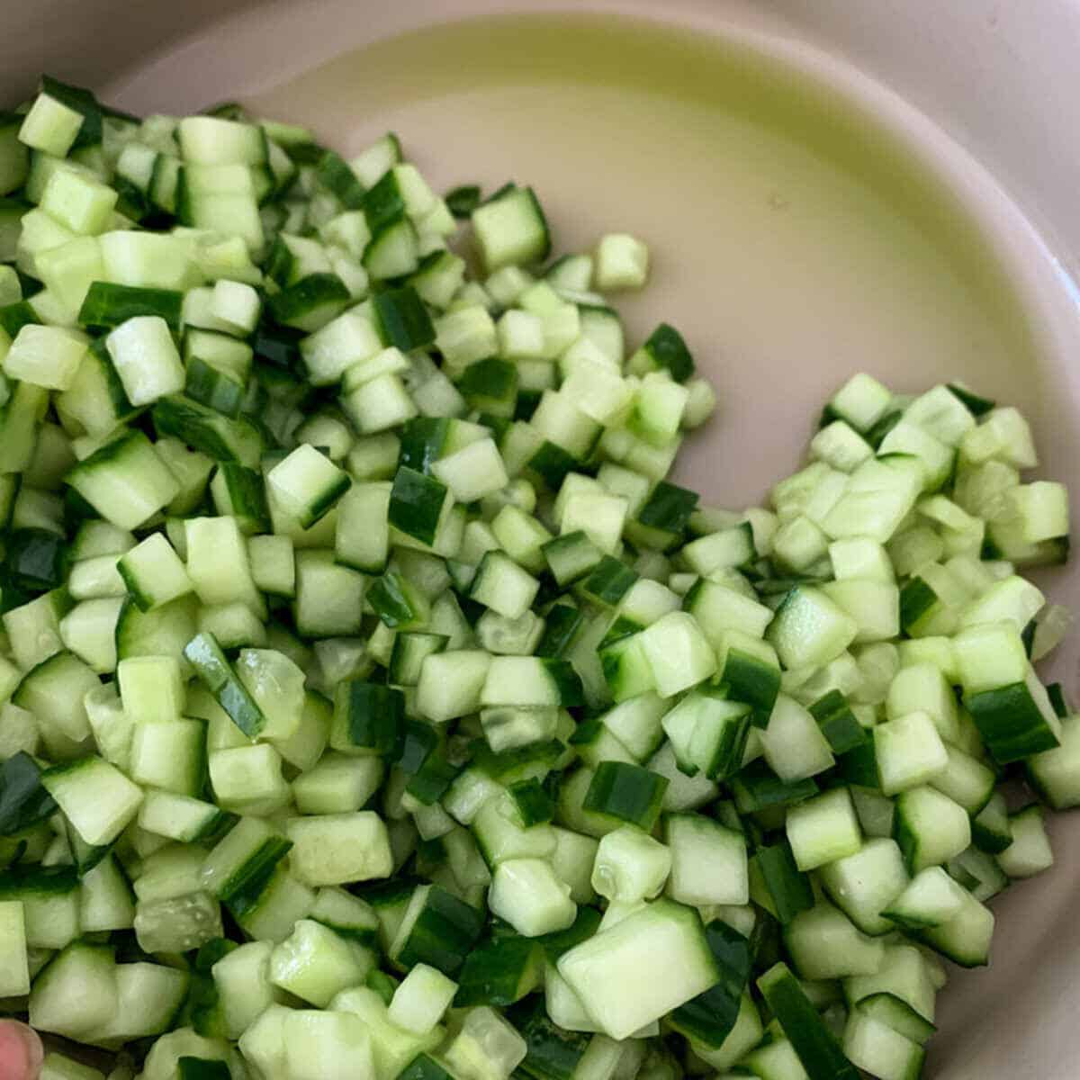 Salted diced cucumber for dosakaya pachadi releasing its juices before making the chutney.