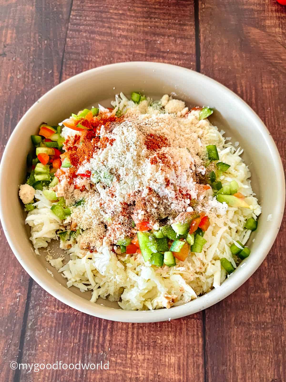 Smoked paprika, almond flour, and spices were added on top of shredded paneer and potato before mixing.